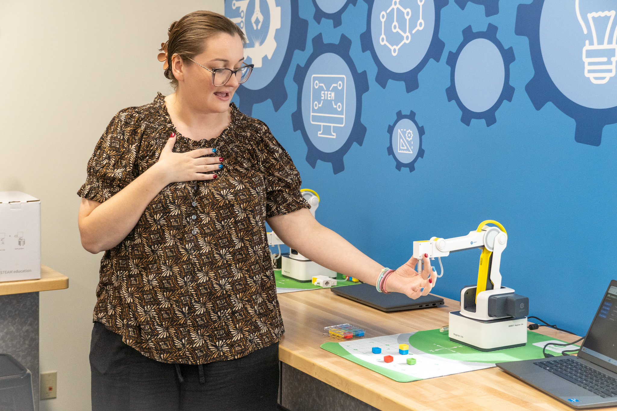 STEM Coordinator Lydia Jones demonstrating robot arm.