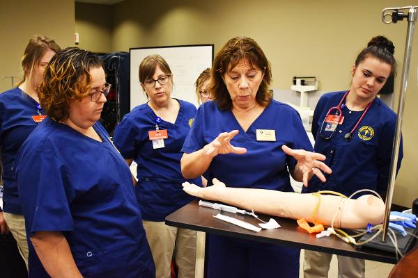 Vincennes University Center for Health Sciences Nursing Students being instructed on how to do draws on a simulated patient arm